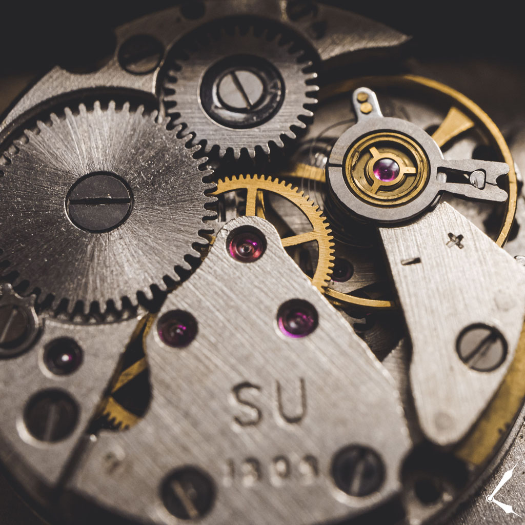 Detailaufnahme eines mechanischen Uhrwerks mit ineinandergreifenden Rädern und Trieben